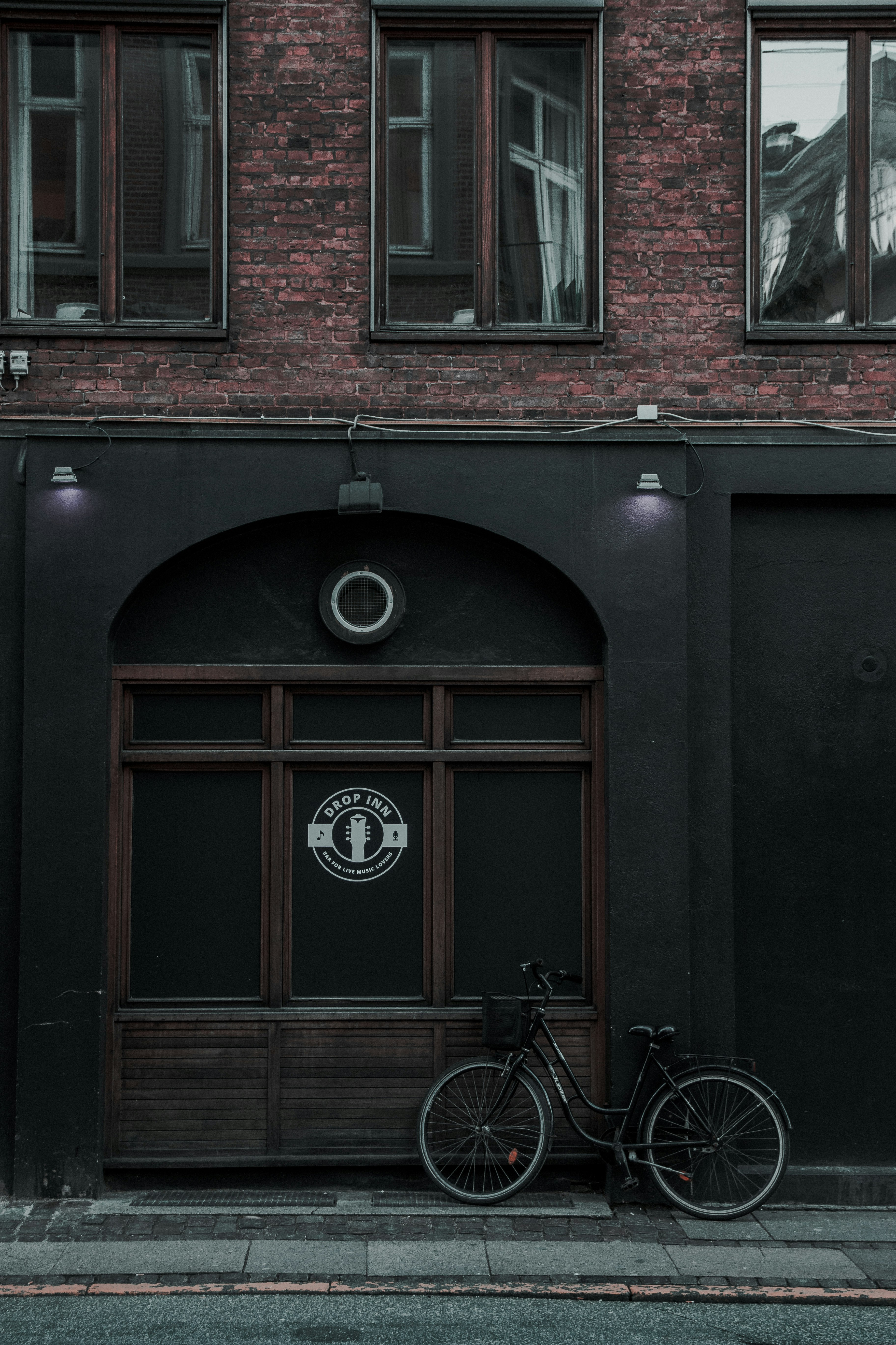 black city bike parked beside building during daytime